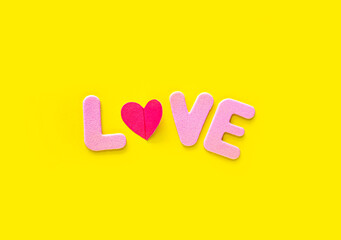 Pink Love text isolated on yellow background with copy space.