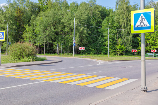 Pedestrian crossing with yellow and white stripes.