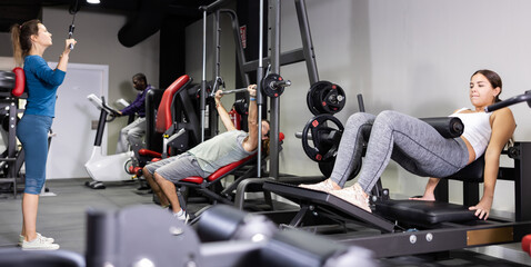 Fototapeta na wymiar Multiple people using fitness machines in gym