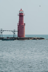 Fototapeta na wymiar Algoma Pierhead Lighthouse - Lake Michigan, in Wisconsin, as a boat passes by