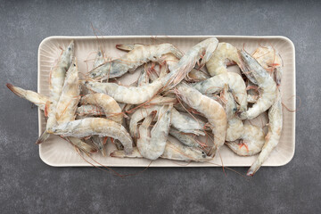 Fresh frozen shrimp is in the plate. The plate contains freshly frozen tiger prawns. Fresh uncooked shrimp. Cooking and marine products.