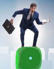 Businessman balancing on top of dice stack in uncertainty concep