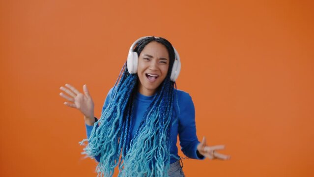 Positive woman dances listening to music in headphones