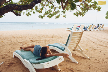 Fototapeta na wymiar woman sea sand summer beach resort ocean lying sunbed lifestyle smiling