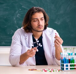 Young male scientist sitting in the classroom