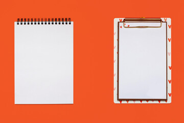 Two notepads with white blank sheets on an orange background. Two different notepads with white sheets with free space for text or drawing. Free space for text
