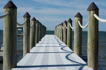 Closeup of wooden pier with rope railing on sunny day