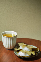 Japanese Kashiwa mochi and green tea. Japanese mochi with red bean paste filling wrapped with an oak leaf. Japanese sweets.