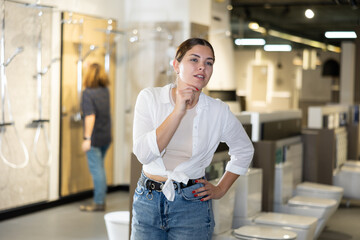 Portrait of female customer making a choice in a plumbing and building materials store