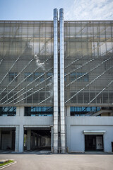 Two metal pipes on a factory exterior wall