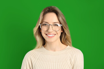 Chroma key compositing. Happy young woman smiling against green screen