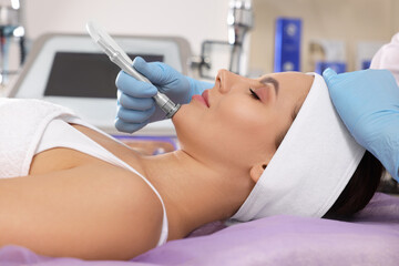 Young woman undergoing cosmetic procedure in beauty salon. Microcurrent therapy