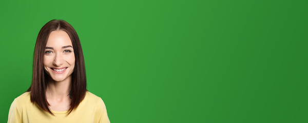 Chroma key compositing. Beautiful young woman smiling against green screen