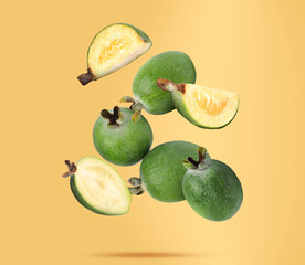 Fresh feijoa fruits falling on orange background