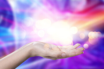 Aura phenomena. Woman with lights of energy coming out from her hand against color background, closeup