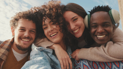Happy smiling friends make a video call from a mobile phone. Four students wave their hands in greeting