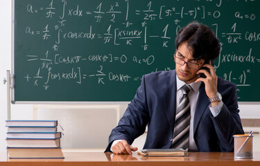 Young male math teacher in classroom