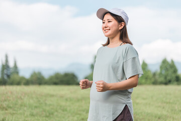 公園で運動・散歩・ウォーキング・有酸素運動・ランニングする妊婦の女性
