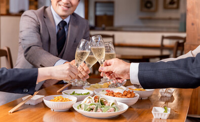 居酒屋で忘年会・新年会・飲み会・宴会をする仕事仲間・同僚・上司部下の男女
