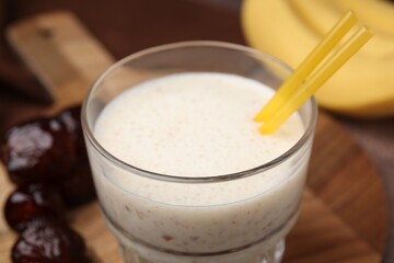 Glass of delicious date smoothie on board, closeup