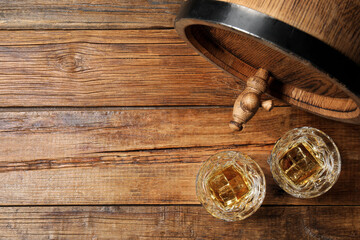 Glasses of whiskey and wooden barrel on table, flat lay. Space for text