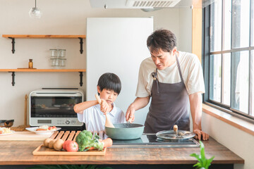 家のキッチンで子供と一緒に料理・クッキング・お手伝いする子供・親子・家族  © buritora