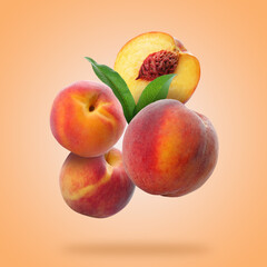 Juicy fresh peaches with green leaves falling on light coral background