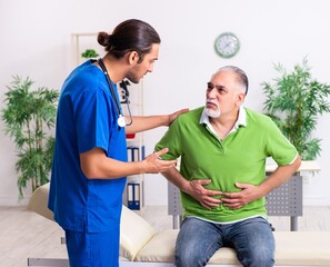 Fototapeta premium Old man visiting young male doctor gastroenterologist