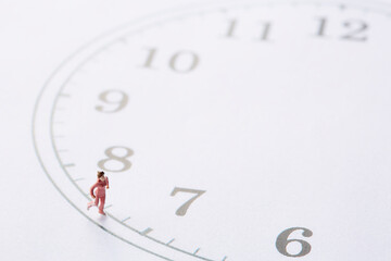 時計の文字盤の周りを走るミニチュア人形の女性