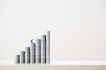 積み上げられた一円硬貨とミニチュアの人