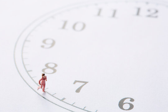 時計の文字盤の周りを走るミニチュア人形の女性