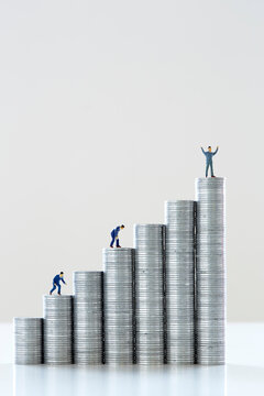 積み上げられた一円硬貨とミニチュアの人