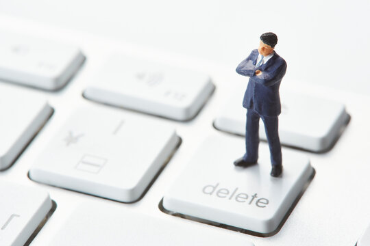 キーボードの上で腕を組むミニチュア人形