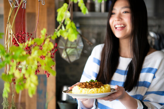 料理の乗ったお皿を持っている女性