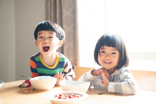 食卓で笑っている兄妹
