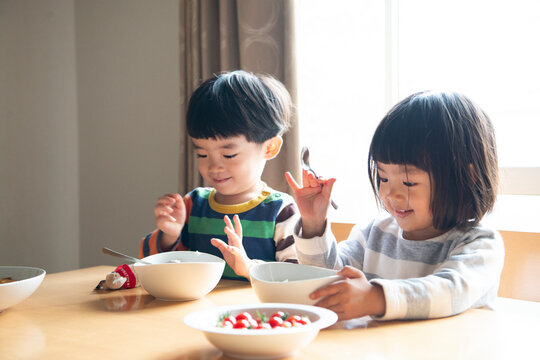 食卓で笑っている兄妹