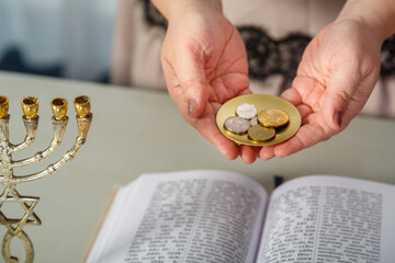 A Jewish woman reads a blessing on family wealth before the wedding, silver shekels in her hands...