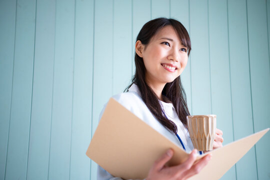 ファイルを開いてカップを持っている女性