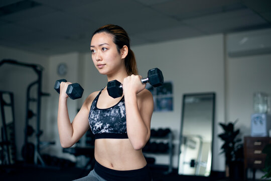 ダンベルで筋トレをしている女性