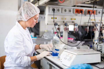 Young adult woman lab technician working in research laboratory, conducting experiment