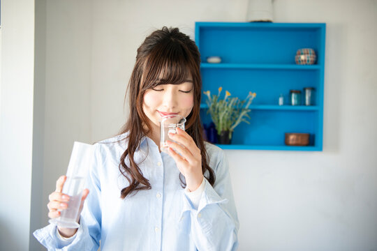 アロマオイルの香りをビーカーから嗅いでる女性