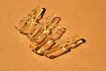 Glass ampoules on a beige orange background.