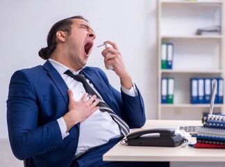 Sick male employee suffering at workplace