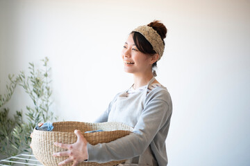 洗濯物の入ったかごを持っている女性