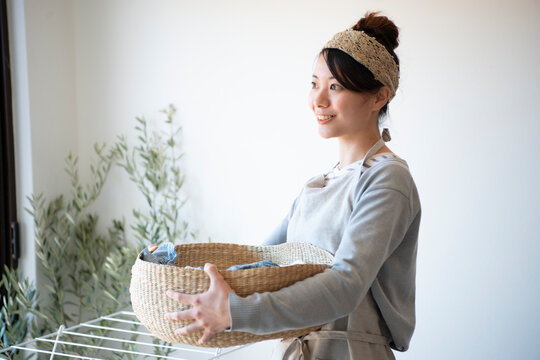 洗濯物の入ったかごを持っている女性