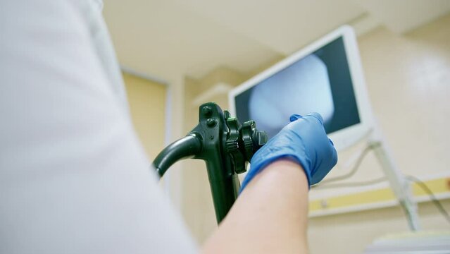 Close-up of doctor's gloved hand with endoscope during diagnostic gastroscopy or colonoscopy in clinic