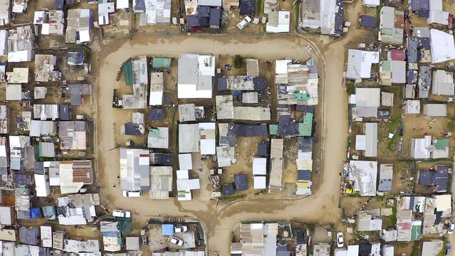 Drone, township and shack buildings in South Africa, Gugulethu or neighborhood outdoor. Aerial view, slums and area, land or landscape with poverty, infrastructure and poor village, street or shanty.
