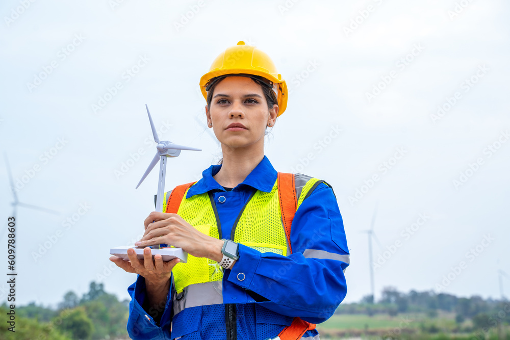 Poster Engineer man looking and checking wind turbines at field,Wind turbine farm generator by alternative green energy.