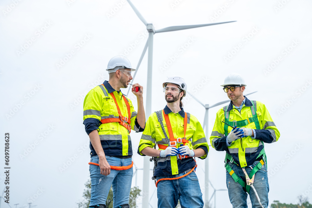 Poster engineer with technician are inspection work in wind turbine farms rotation to generate electricity 