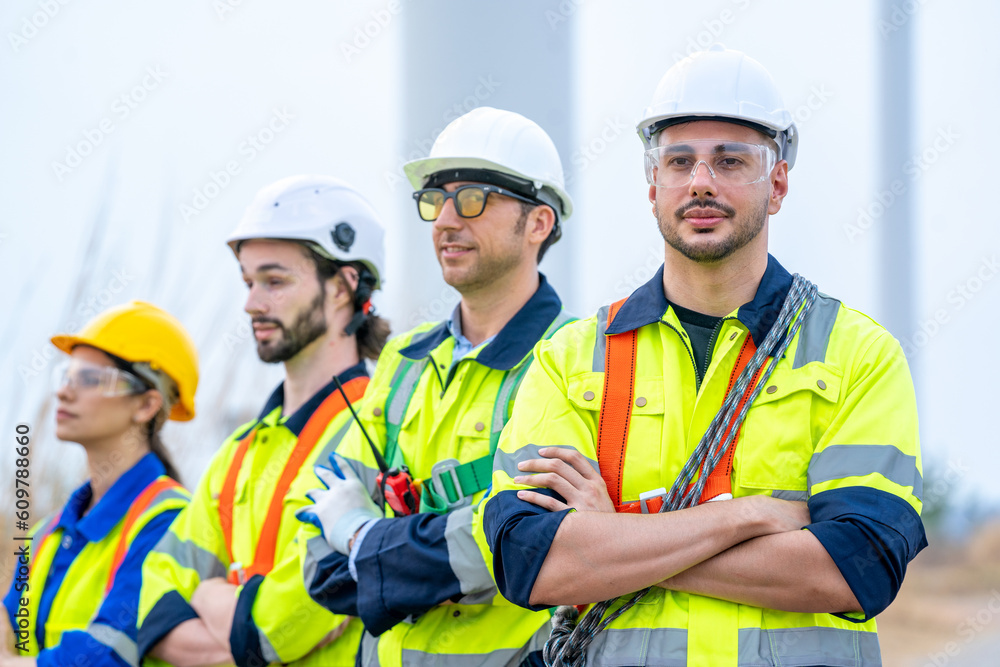Poster engineer with technician are inspection work in wind turbine farms rotation to generate electricity 